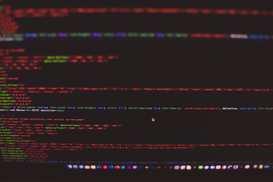 A close-up digital screen displaying lines of programming code composed of colored text in red, green, blue, and purple on a dark background. The code features HTML and CSS elements, with visible tags