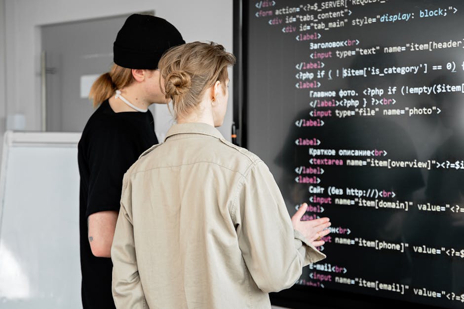 A close-up digital screen displaying lines of programming code composed of colored text in red, green, blue, and purple on a dark background. The code features HTML and CSS elements, with visible tags
